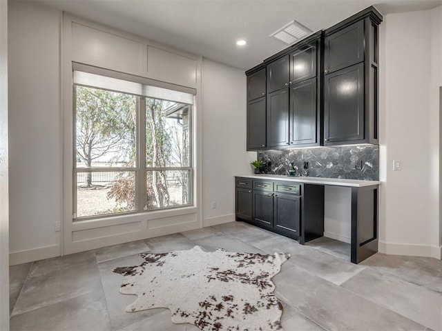 bar with baseboards, backsplash, and recessed lighting