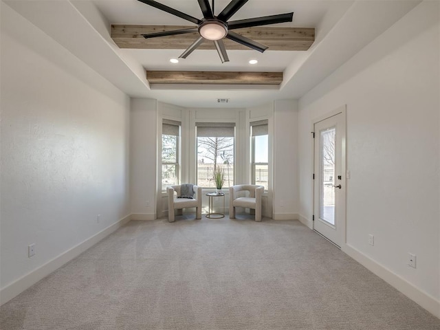 unfurnished room with light carpet, baseboards, visible vents, a ceiling fan, and a tray ceiling