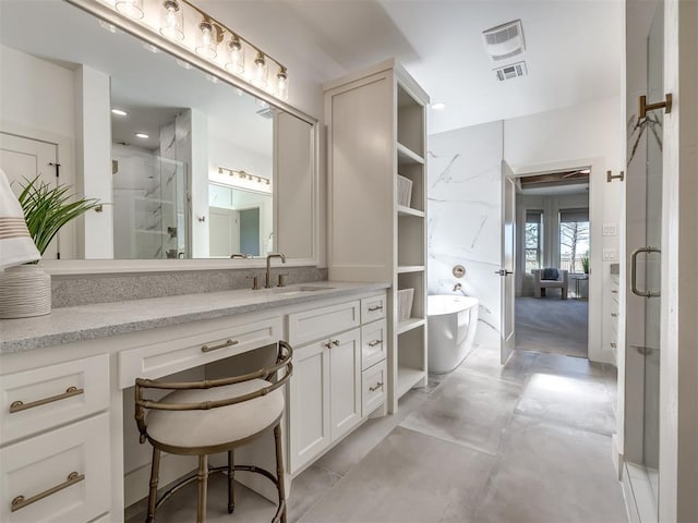 bathroom featuring a stall shower, a freestanding tub, visible vents, and vanity