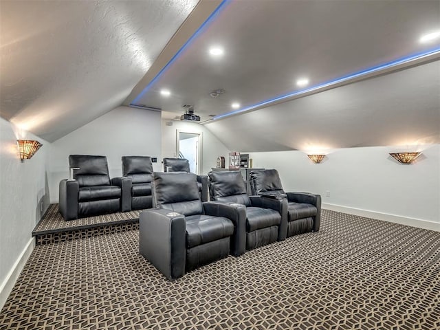 carpeted cinema room with vaulted ceiling, a textured ceiling, recessed lighting, and baseboards