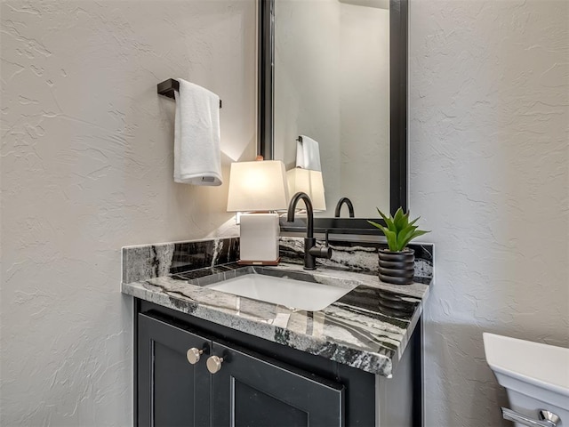 bathroom with vanity and a textured wall