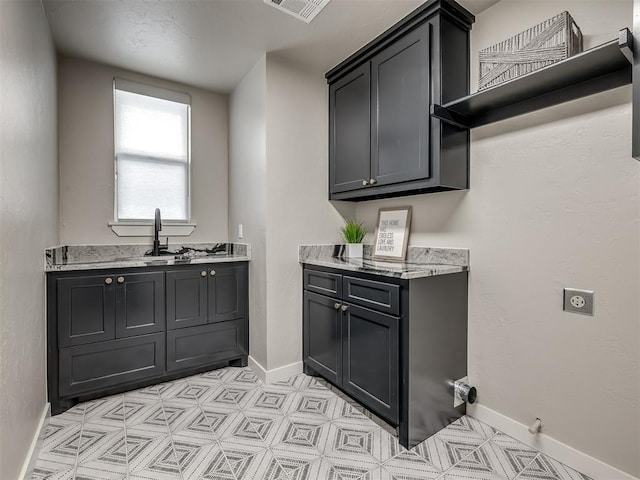 interior space featuring a sink, visible vents, and baseboards