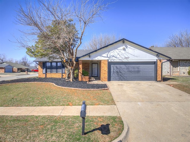 view of front of home with concrete driveway, brick siding, a front lawn, and an attached garage