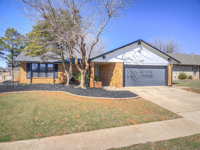 view of front of house with a garage, a front yard, brick siding, and driveway