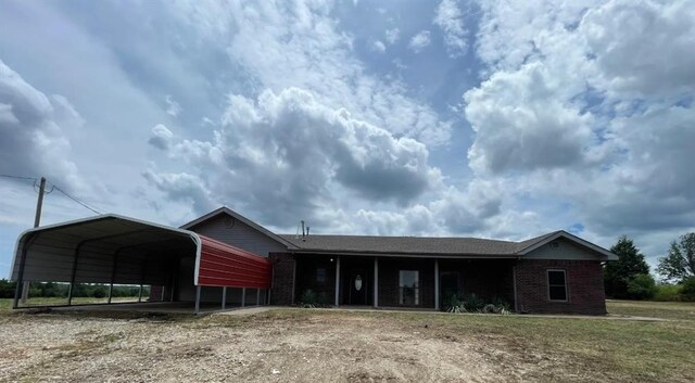 view of front of house featuring a detached carport and brick siding