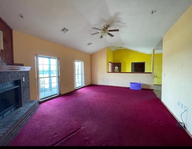 unfurnished living room featuring carpet floors, a fireplace, visible vents, a ceiling fan, and vaulted ceiling