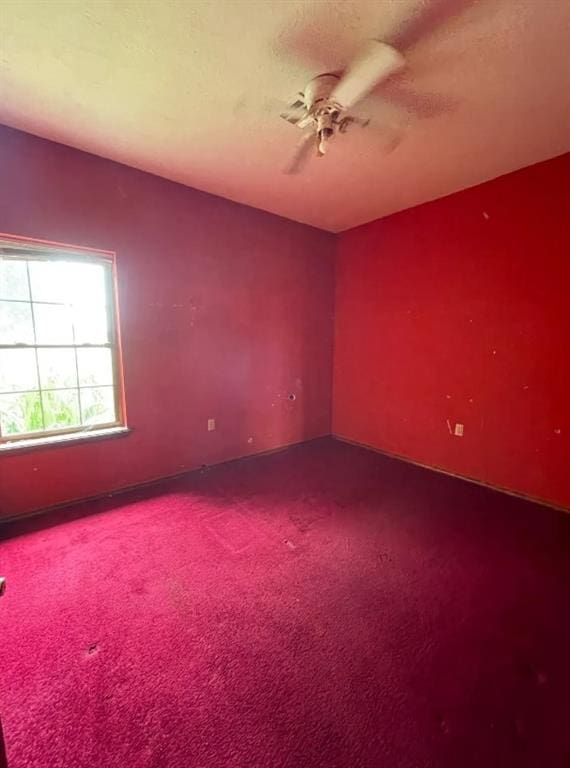 empty room with carpet, ceiling fan, and a textured ceiling