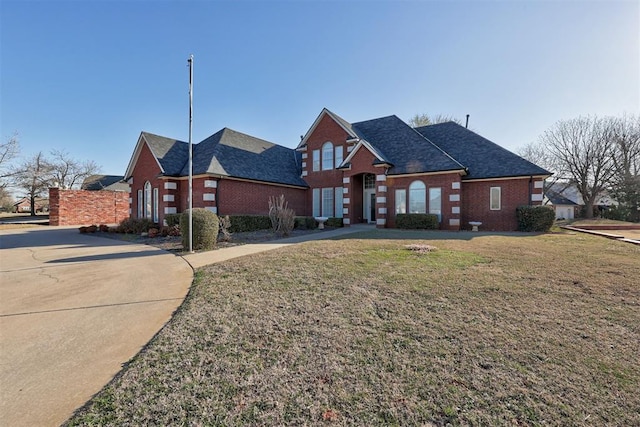 traditional-style house featuring brick siding and a front yard