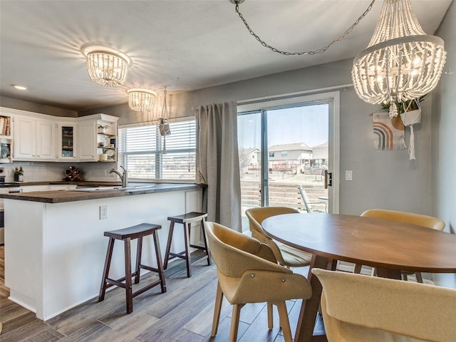 dining space with an inviting chandelier, light wood finished floors, and recessed lighting