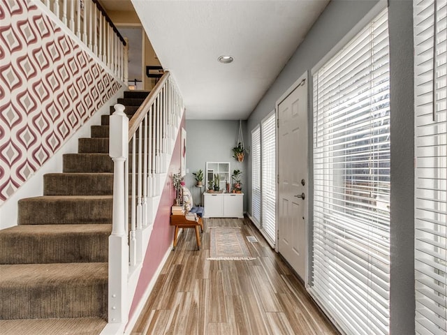 entrance foyer featuring stairs and wood finished floors