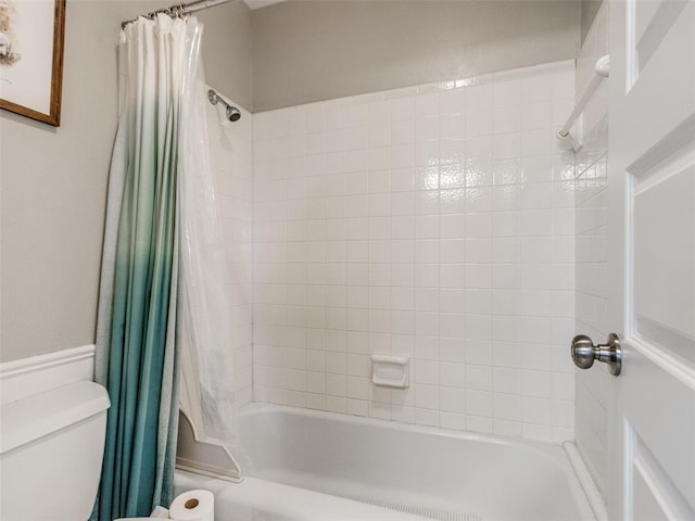 full bath featuring wainscoting, shower / bath combination with curtain, and toilet