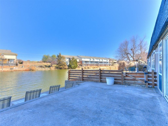 view of patio / terrace with a water view and fence