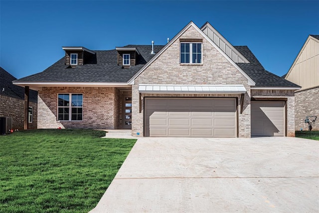 view of front facade with roof with shingles, an attached garage, a front lawn, concrete driveway, and brick siding