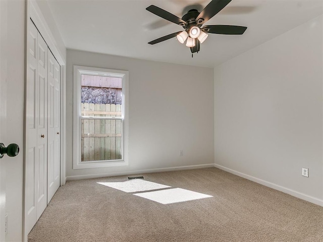 unfurnished room with ceiling fan, carpet, and baseboards