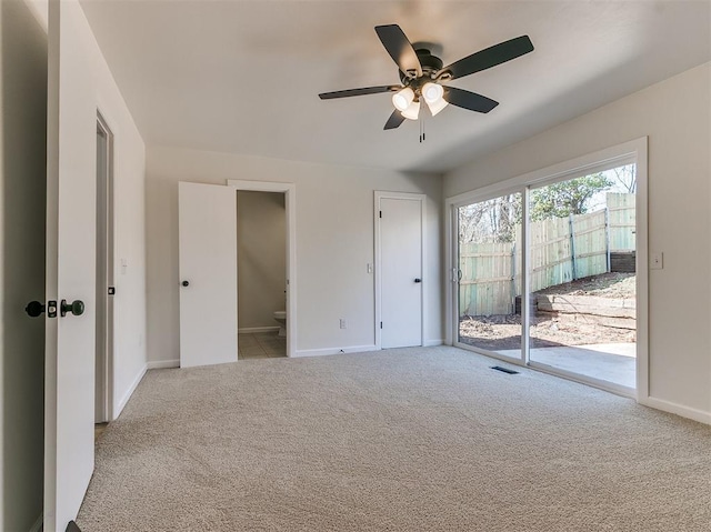 unfurnished bedroom featuring baseboards, a ceiling fan, ensuite bathroom, access to exterior, and carpet flooring