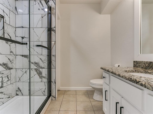 full bathroom featuring tile patterned flooring, toilet, vanity, baseboards, and an enclosed shower