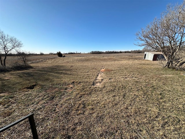 view of yard with an outdoor structure and a rural view