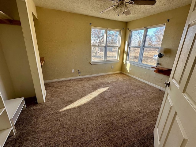 unfurnished bedroom featuring ceiling fan, baseboards, carpet floors, a textured wall, and a textured ceiling