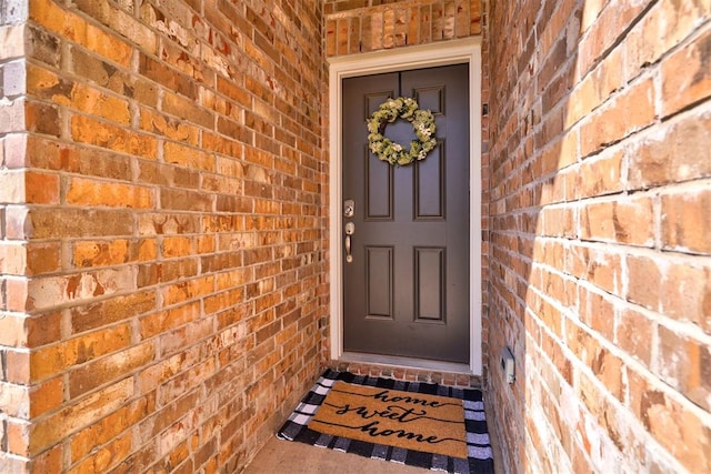 doorway to property featuring brick siding