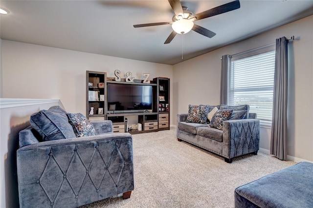 living room featuring carpet floors, baseboards, and a ceiling fan