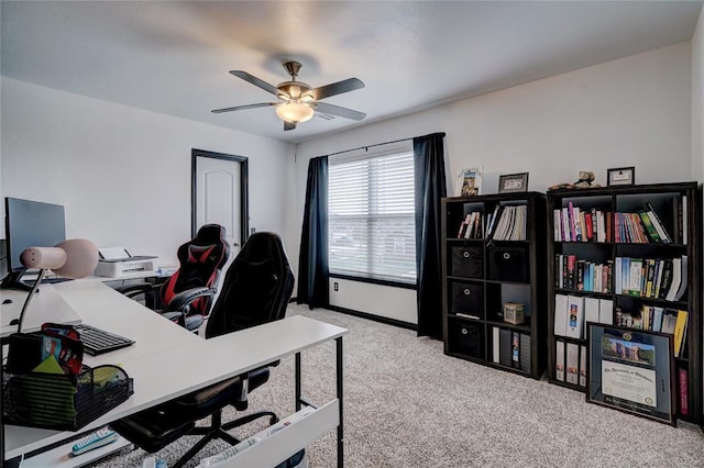 carpeted home office featuring a ceiling fan and baseboards