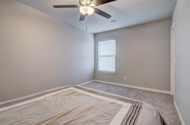 unfurnished bedroom with carpet, baseboards, visible vents, and a ceiling fan