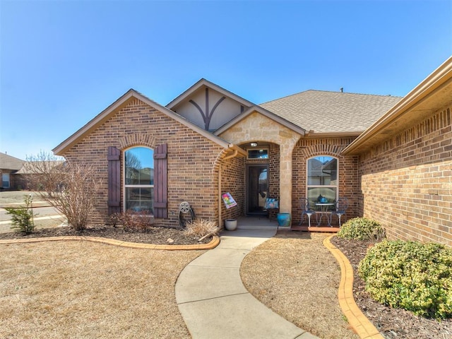 property entrance with brick siding and a shingled roof