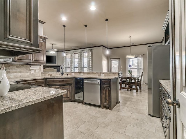 kitchen with light stone countertops, ornamental molding, decorative backsplash, dark brown cabinets, and appliances with stainless steel finishes