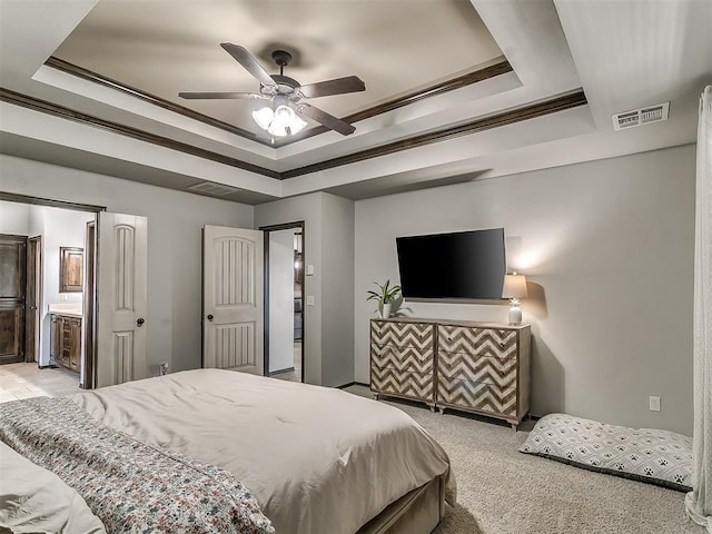 bedroom with a tray ceiling, crown molding, light colored carpet, and visible vents