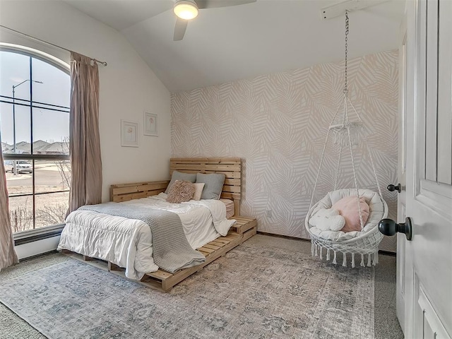 carpeted bedroom with wallpapered walls, vaulted ceiling, multiple windows, and ceiling fan