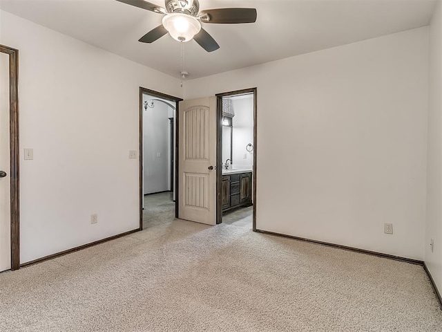 unfurnished room with light carpet, baseboards, a ceiling fan, and a sink