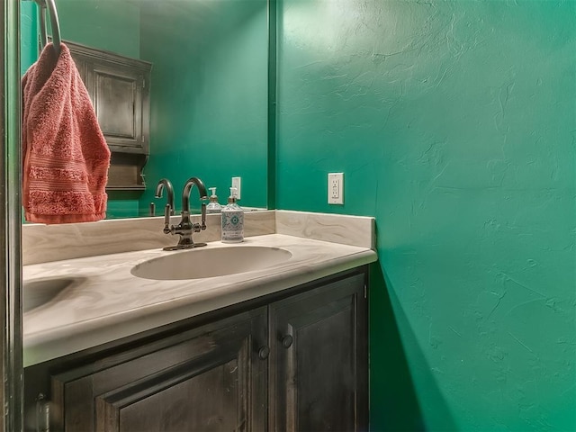 bathroom with vanity and a textured wall