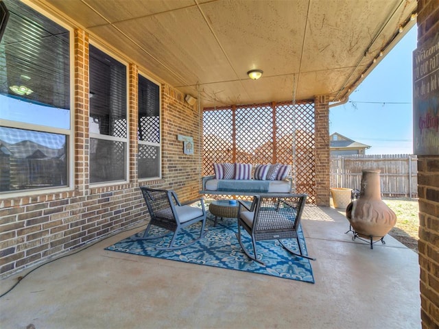 view of patio featuring outdoor lounge area and fence