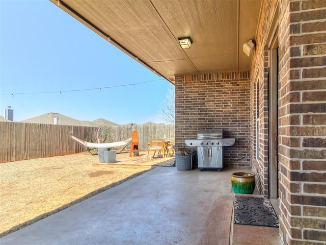 view of patio with area for grilling and fence