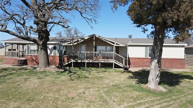 view of front of property with stairs, a front yard, and brick siding