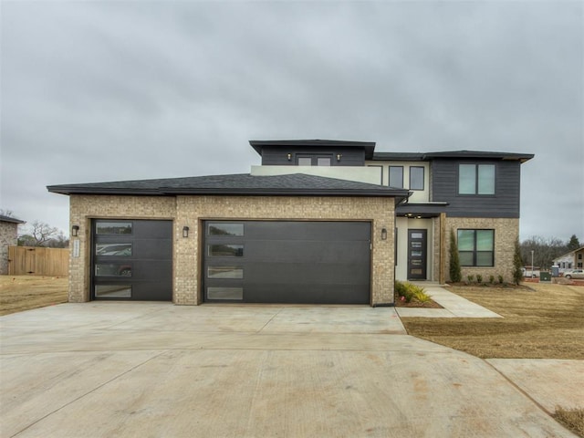 view of front of home with a garage, driveway, brick siding, and fence