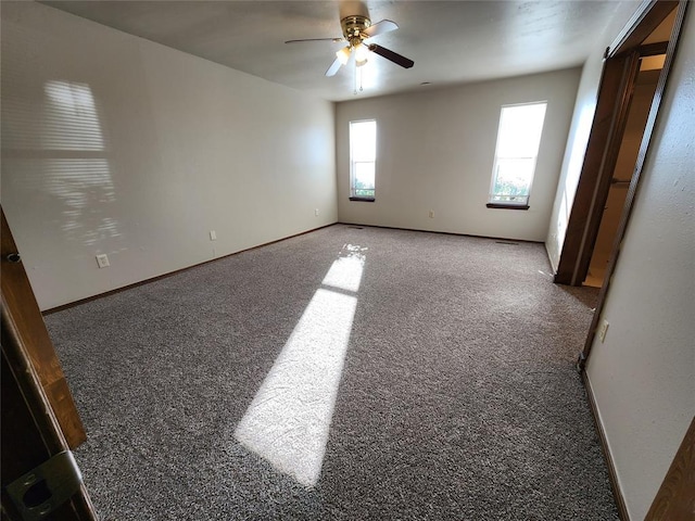 carpeted empty room featuring a ceiling fan and baseboards