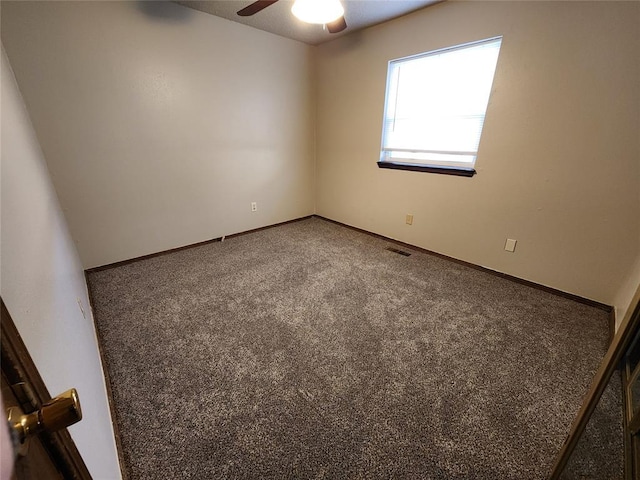 carpeted spare room with a ceiling fan, visible vents, and baseboards