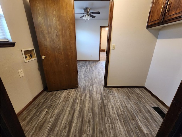 hall featuring wood finished floors, visible vents, and baseboards