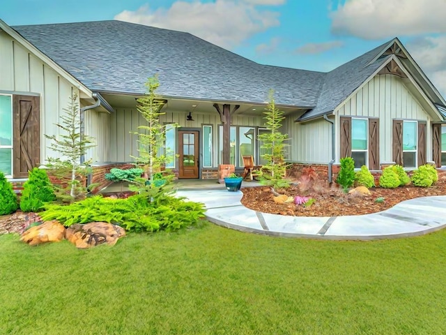 back of property featuring roof with shingles, board and batten siding, and a lawn