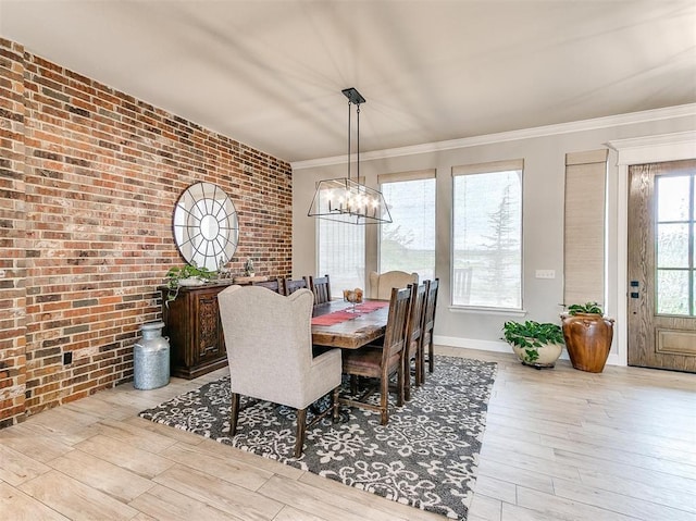 dining room with wood finished floors, a notable chandelier, brick wall, and ornamental molding