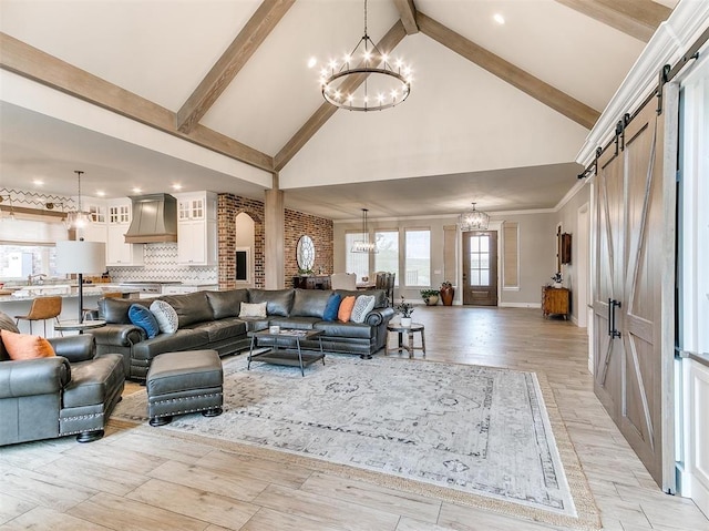 living room with a barn door, a notable chandelier, and beamed ceiling