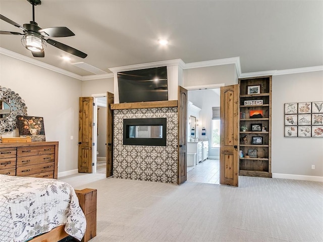 bedroom featuring a tiled fireplace, crown molding, light colored carpet, and baseboards