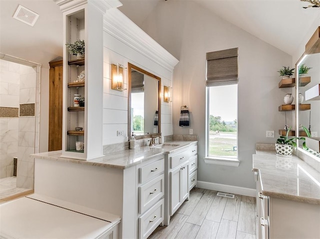 full bath with vaulted ceiling, plenty of natural light, a walk in shower, and visible vents