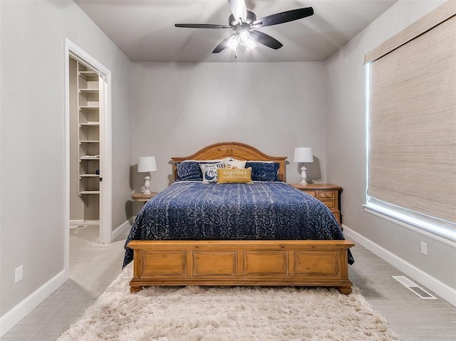 bedroom with visible vents, baseboards, light carpet, and ceiling fan