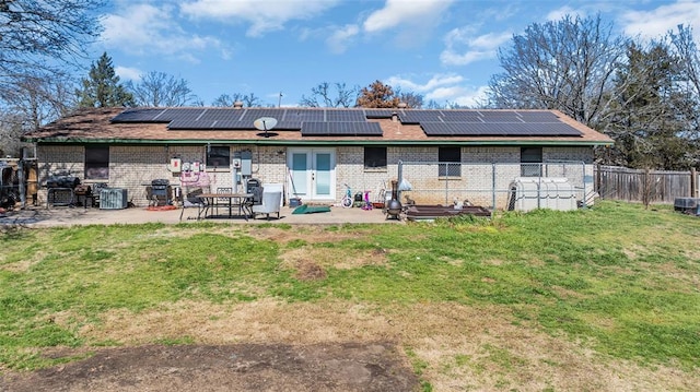 rear view of property featuring a patio area, a yard, brick siding, and fence