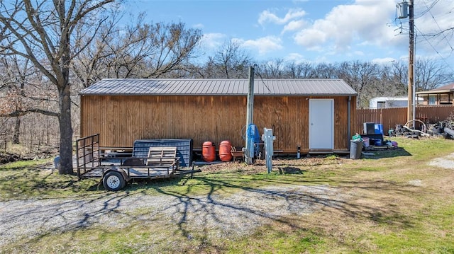 view of pole building with a lawn and fence