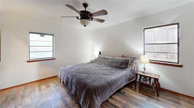 bedroom featuring ceiling fan, baseboards, and wood finished floors