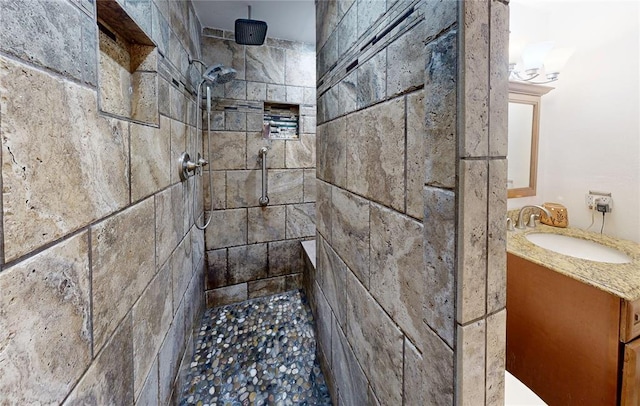 full bathroom with tiled shower and vanity