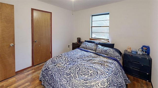 bedroom featuring wood finished floors and baseboards